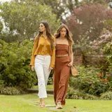 Zapatillas deportivas color beige con detalles dorados, cordones al tono y suela blanca.