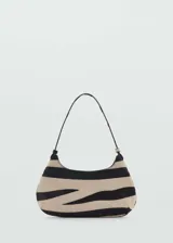 Bolso de hombro pequeño con estampado de cebra en tonos beige y negro. Tiene cierre de botón magnético, asa corta y forro interior de algodón.