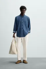 Pantalón verde oscuro de algodón con textura, corte recto, cintura elástica ajustable con cordón, bolsillos laterales y traseros de vivo.