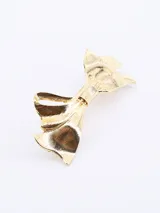 Broche para el pelo dorado con forma de moño.