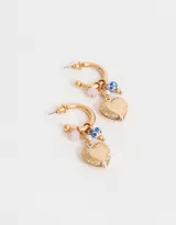 Aros dorados tipo argolla con dije de corazón con diseño floral, perlas y cuentas de cerámica con diseño floral.