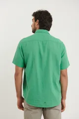 Camisa sport de manga corta color verde oliva, línea premium, con cuello clásico, cierre frontal con botones de coco y bolsillo de parche en el pecho. Confeccionada en lino y algodón.