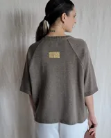 Sweater color beige de tejido de punto con mangas cortas y cuello redondo.