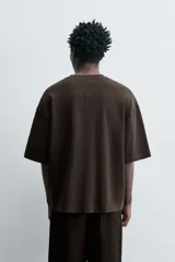 Camiseta negra de corte cuadrado (boxy fit), cuello redondo y mangas cortas. Detalle de costuras en delantero y espalda.