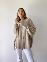 Sweater de punto color beige, de corte holgado y mangas largas.