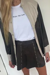 Minifalda negra con tachas doradas en el frente.