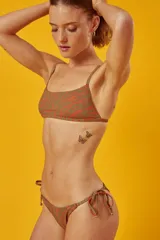 Conjunto de bikini con estampado animal print, compuesto por un corpiño bandeau con breteles finos y una bombacha vedetina con tiras laterales ajustables.