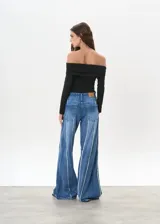 Pantalón de jean de tiro medio, corte wide leg, color azul con costuras verticales blancas en el frente.