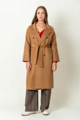 Tapado largo color camel, confeccionado en lana. Tiene doble botonadura, cuello con solapa y lazo para ajustar en la cintura.