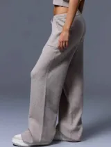 Conjunto de chaleco corto de punto con botones y pantalón de punto con bolsillos grandes y lazo en la cintura, color beige.
