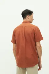 Camisa de manga corta color beige claro, confeccionada en lino y algodón, con fit regular y logo bordado en el pecho.
