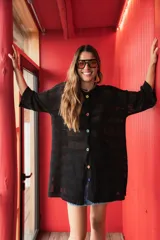 Camisa tejida en hilo de algodón, color negro, con calce oversize y largo medio. Diseño de rayas caladas y botones de distintos colores.