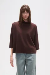 Polera holgada de poliéster color verde militar, con cuello alto tipo tortuga y mangas tres cuartos.