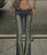 Jean tiro bajo de mezclilla azul con efecto gastado y paneles con costuras curvas que recorren las piernas. Presenta cierre frontal y corte ligeramente acampanado en la botamanga.