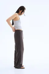 Pantalón recto gris oscuro de tejido vaporoso en mezcla de lino. Modelo holgado con elástico y cordón de ajuste en la cintura, bolsillos laterales y traseros insertados.