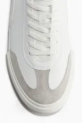 Championes deportivos blancos de estilo retro en tejido revestido con detalles en tejido cepillado gris. Collarín acolchado, lengüeta y cordones. Forro y plantillas de malla. Suelas de goma con diseño.