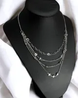 Collar de múltiples cadenas plateadas, con dijes de corazones y bolitas. Largo total aproximado 24cm.