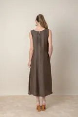 Vestido midi marrón de tejido tramado, corte suelto, sin mangas y con bolsillos laterales.