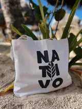 Bolso tipo tote bag de lona color crudo, con asas cortas y estampado frontal con el logo de la marca Nativo en negro.