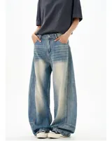 Jean de denim azul claro con efecto lavado y amplios paneles deslavados en la parte delantera de los muslos. Presenta un corte extremadamente ancho y holgado (baggy), con puños ajustados en los tobillos.