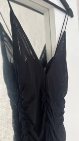 Vestido corto negro de microtul con escote en V y breteles finos.