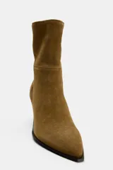 Botín de gamuza color marrón con puntera y cierre lateral con cremallera. Tacón bloque de 8 cm de altura.