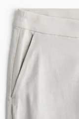 Pantalón ancho color crudo, de tiro alto, con bolsillos laterales y cierre oculto.