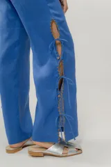 Pantalón negro de lino con aberturas laterales con cordones y bordado a contratono. Cuenta con un bolsillo trasero tejido a mano en crochet.