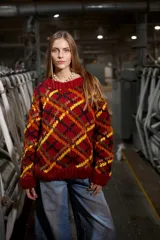 Sweater de lana tejido y bordado a mano en Uruguay, de calce holgado con cuello a la base y puños. Diseño con rombos en tonos rojo, negro, amarillo y marrón.