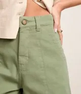 Short de cintura alta en sarga color beige, con bolsillos y costura aparente.
