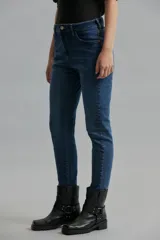 Jeans slim de tiro medio confeccionado en tejido elastizado. Presenta una silueta ajustada que se ancla en la cintura y mitad de muslo, enderezándose en la rodilla hasta el tobillo.