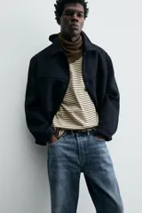 Pantalón de jean azul de corte recto, con cinco bolsillos, efecto lavado y cierre frontal con botones.