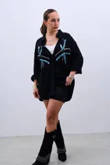 Camisa negra de corte amplio con botones y estampado de líneas con lentejuelas en color celeste y plateado.