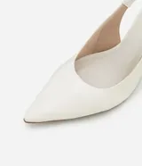 Zapato de tacón tipo anabela (cuña) color marrón oscuro, con punta fina y diseño slingback con tira elástica en el talón. Confeccionado en poliuretano con acabado liso.