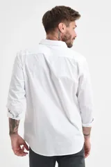 Camisa blanca de manga larga con cuello clásico y cierre frontal con botones.