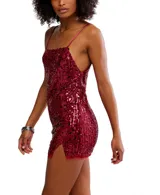 Vestido corto dorado con lentejuelas, escote recto y tirantes finos. Presenta una abertura lateral en la falda y está confeccionado en poliéster y elastano.