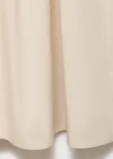 Vestido midi color crudo, de corte evasé, con breteles anchos y escote redondo.