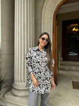Camisa amplia blanca con estampado floral en negro, de corte suelto y manga larga.
