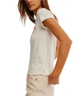 Remera blanca con cuello redondo y estampado frontal con la palabra 'SURF' en color coral.