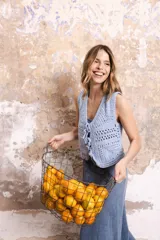 Chaleco corto tejido a crochet color verde oliva, con escote en V y cierre frontal con lazos.