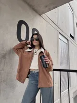 Campera marrón de pana con cierre frontal, cuello de piel sintética y bolsillos laterales.