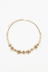 Cinturón plateado de metal con cadena de eslabones y apliques de flores.