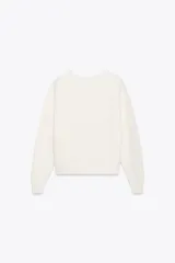 Sweater color blanco de punto perlado, con cuello redondo y mangas largas.