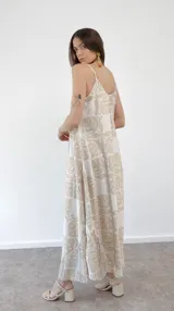 Vestido largo de tirantes finos con estampado de hojas en tonos beige y blanco.