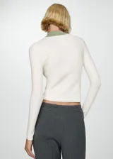 Jersey de punto fino color crudo, con cuello perkins verde y cierre de cremallera.