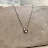 Collar de acero plateado con dije tipo punto de luz adornado con zirconia cúbica, de diseño minimalista.