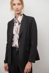 Blazer azul de jean textil, con solapa clásica, un botón frontal y bolsillos laterales.