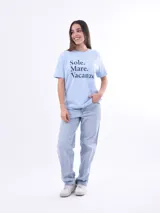 Remera negra de algodón con cuello redondo y mangas cortas. Estampado frontal con la frase "World Tour Vacation State of Mind" en letras de colores y un pequeño dibujo de una palmera.