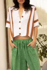 Camisa tejida de algodón color blanco con rayas verticales color tostado, cuello camisero, manga corta y bolsillos al frente.