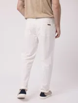 Pantalón de vestir color beige, de corte recto, con bolsillos laterales y traseros. Se ajusta a la cintura con botón y cierre.